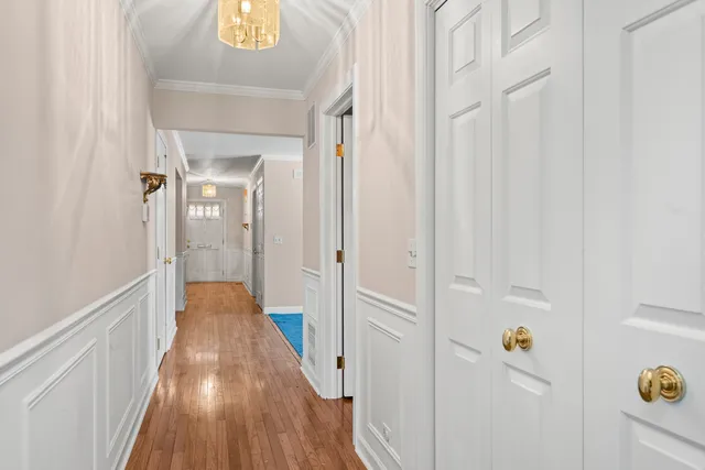 a view of a hallway with wooden floor and staircase