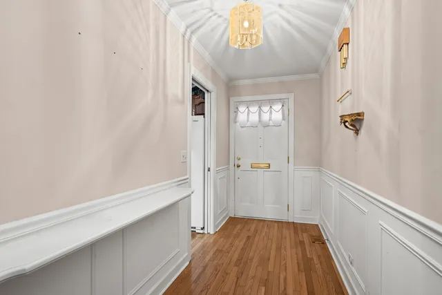 a view of a hallway with wooden floor and closet