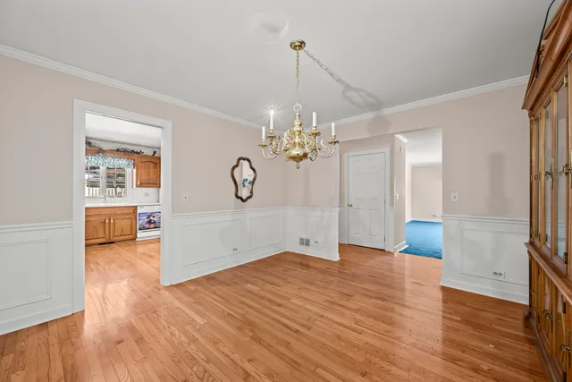 a view of a room with wooden floor and chandelier