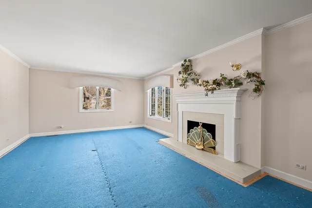 an empty room with a fireplace and wooden floor