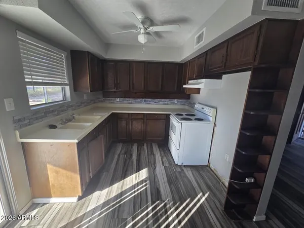a kitchen with sink a refrigerator and wooden cabinets