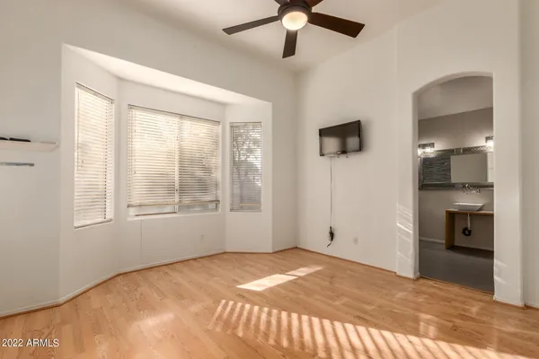 a view of a livingroom with a chandelier fan and windows