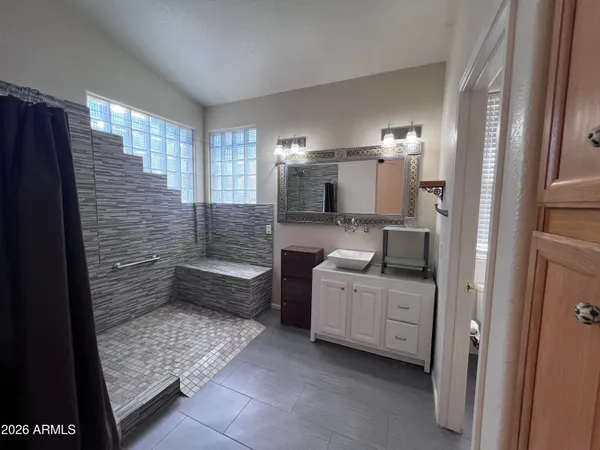 a bathroom with a sink a toilet and shower