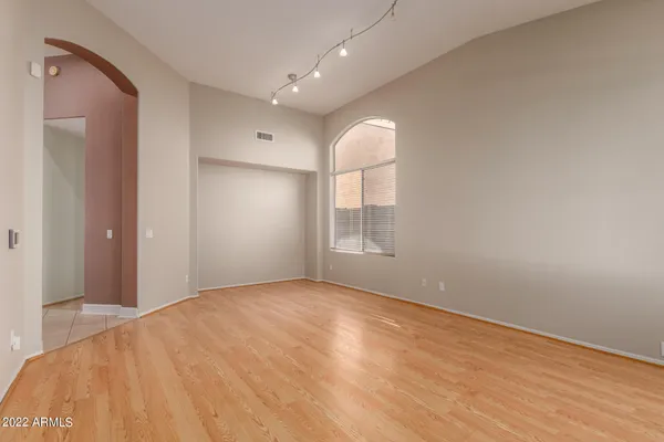 a view of empty room with wooden floor and fan