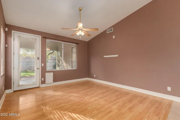 an empty room with windows and chandelier fan