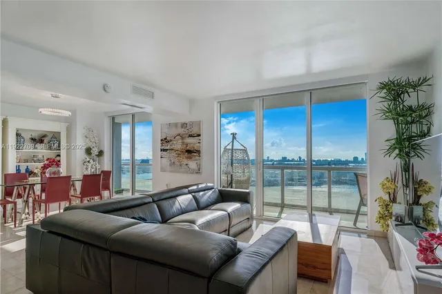 a living room with furniture and a floor to ceiling window