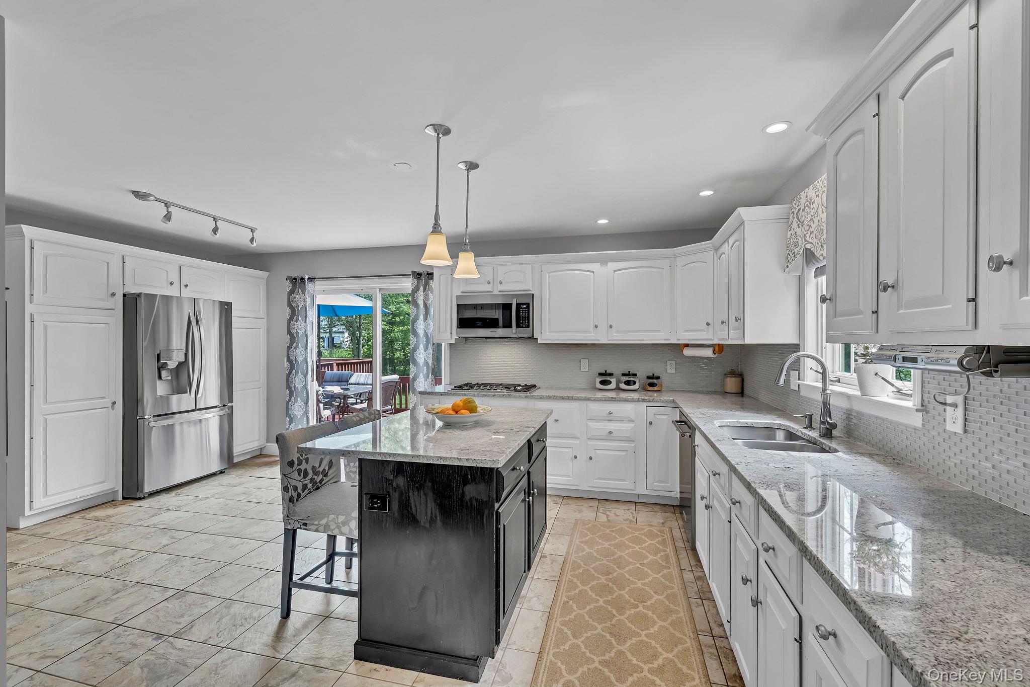 74 Vincent Lane Stone Ridge, NY 12484 - Photo 15 of 49 a kitchen with stainless steel appliances kitchen island granite countertop a sink dishwasher a stove a refrigerator and white cabinets with wooden floor