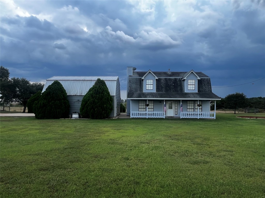 a view of a big house with a big yard and large trees