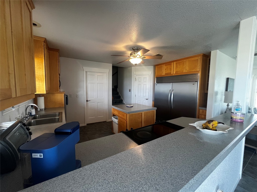 1100 Swiss Alp Hills Loop Schulenburg, TX 78956 - Photo 15 of 40 a kitchen with stainless steel appliances kitchen island granite countertop a sink dishwasher and a refrigerator