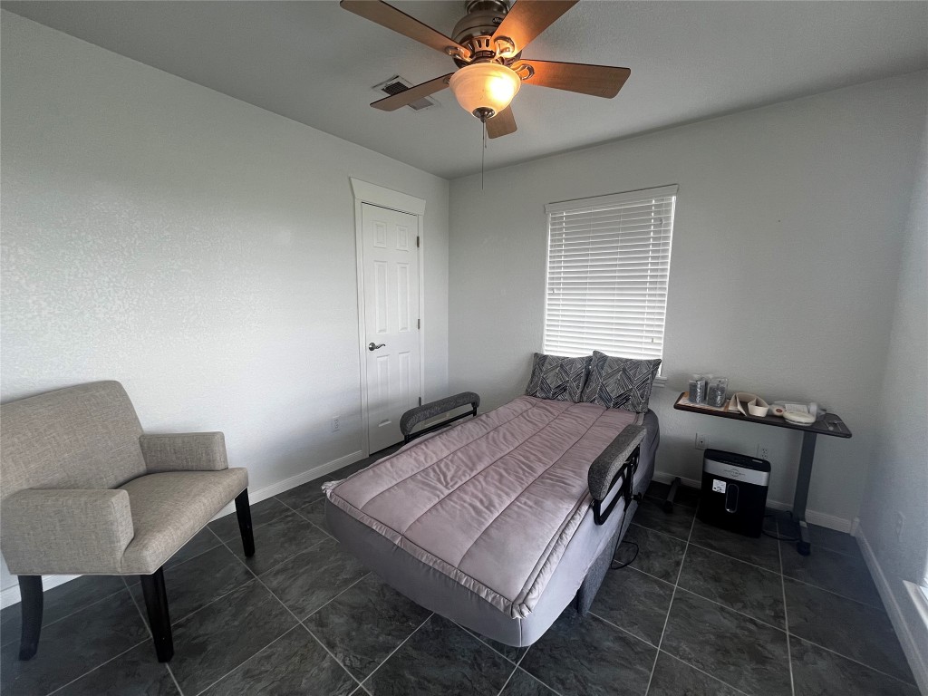 1100 Swiss Alp Hills Loop Schulenburg, TX 78956 - Photo 27 of 40 a bedroom with a bed a chair and a chandelier