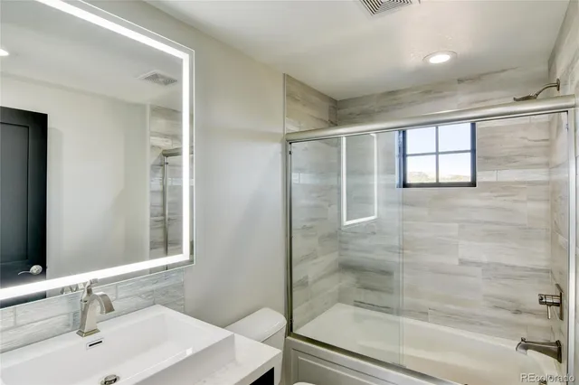 a bathroom with a shower sink and mirror