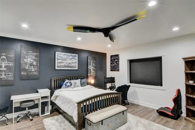 a bedroom with a bed a couch and a flat screen tv