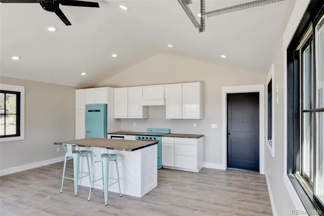 an empty room with windows and ceiling fan