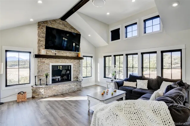 a living room with furniture large window and a fireplace
