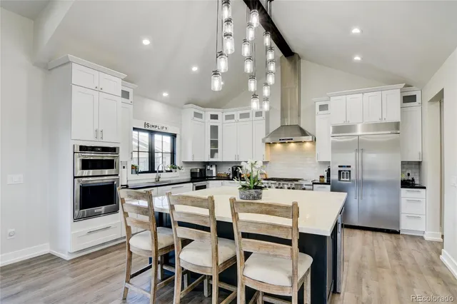 a kitchen with refrigerator a stove and chairs