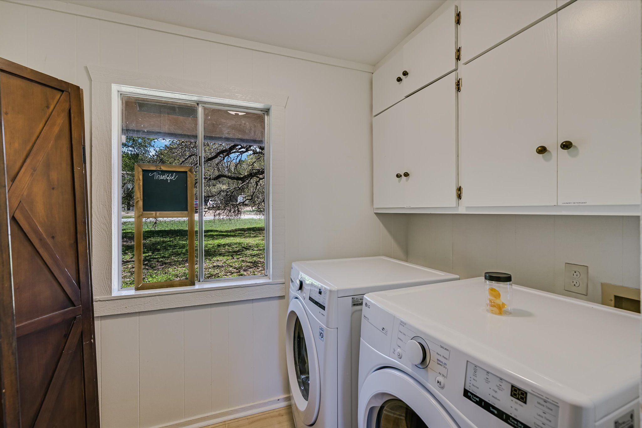 411 Whitetail Ridge Austin, TX 78737 - Photo 12 of 38 Laundry area with wood walls, cabinet space, washer and dryer, and crown molding