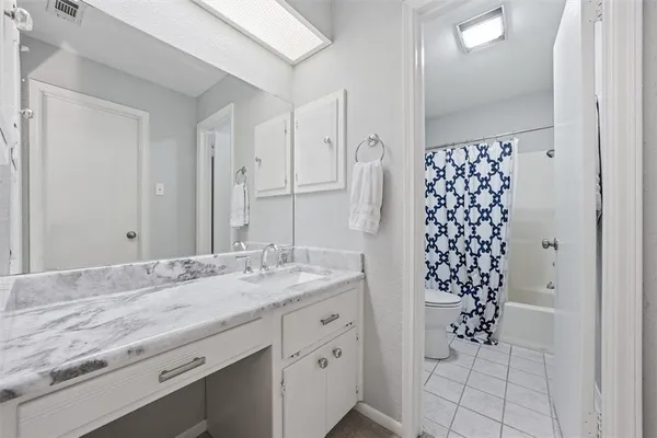 a bathroom with a granite countertop sink a mirror a and a shower