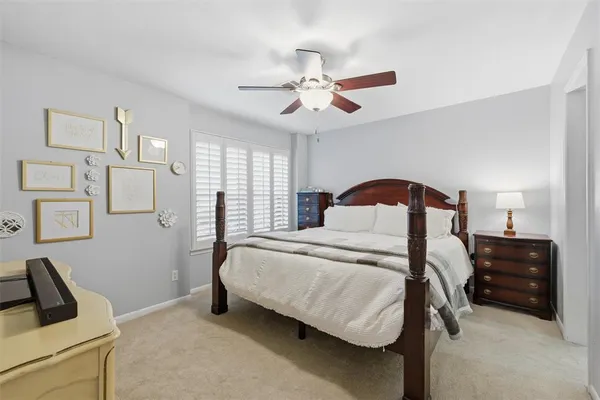 a bedroom with a bed and a ceiling fan