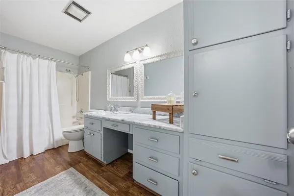 a bathroom with a double vanity sink a toilet and a mirror
