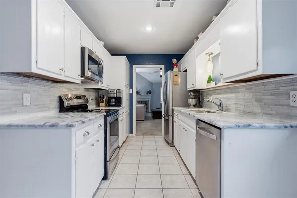 a kitchen with stainless steel appliances granite countertop a sink and cabinets