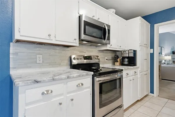 a kitchen with white cabinets stainless steel appliances and sink