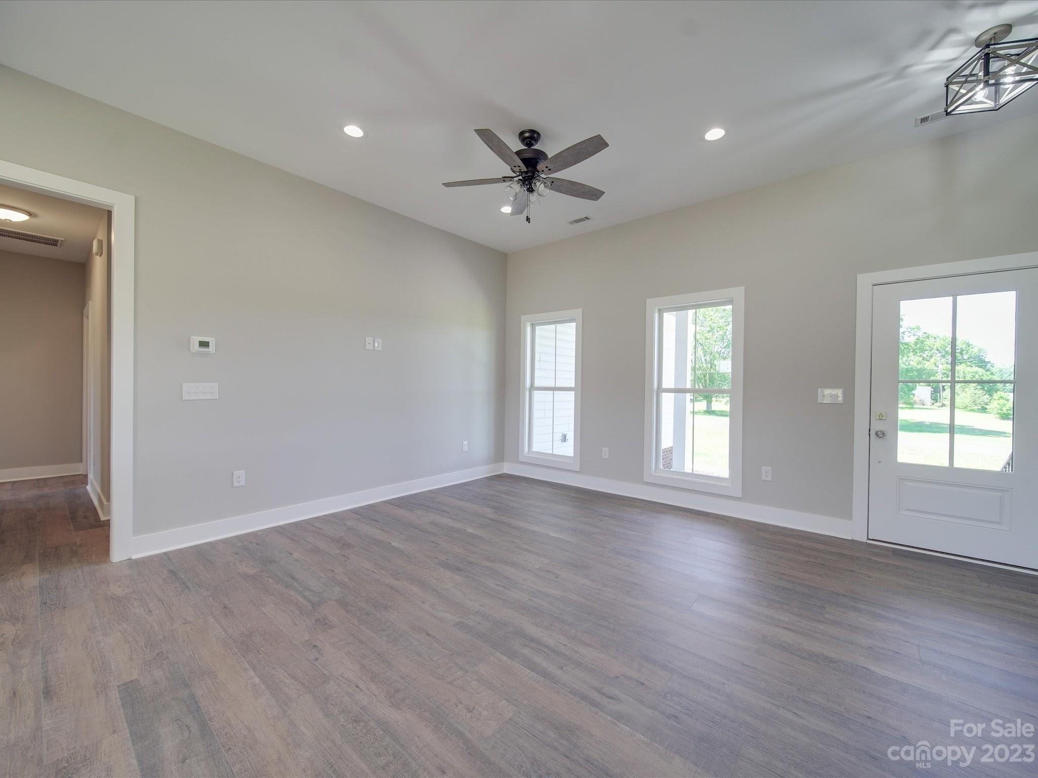 1321 Stack Road Monroe, NC 28112 - Photo 12 of 33 an empty room with wooden floor a ceiling fan and windows