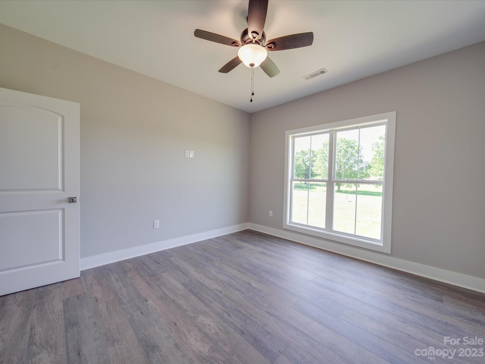 1321 Stack Road Monroe, NC 28112 - Photo 24 of 33 an empty room with wooden floor and windows