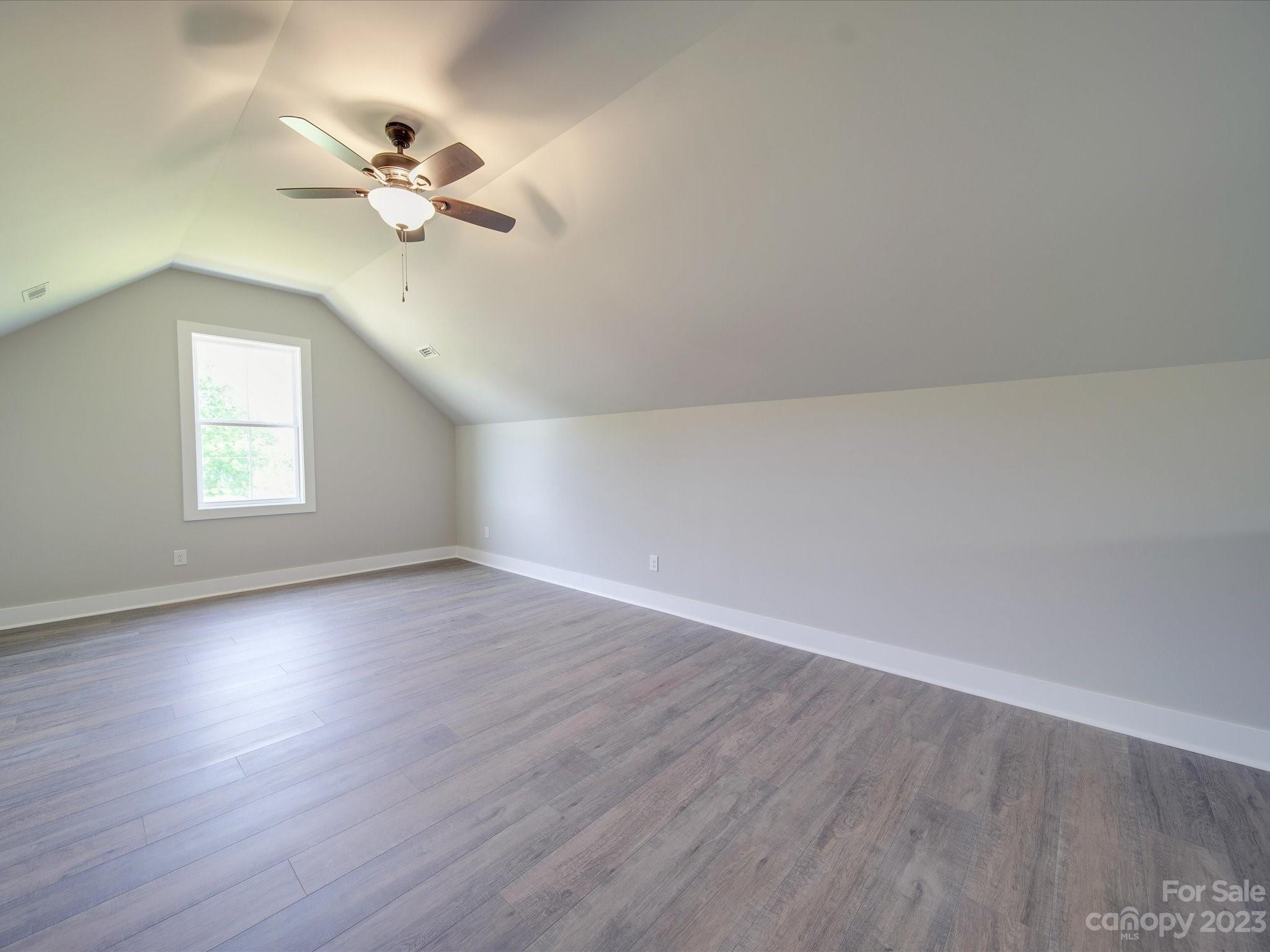 1321 Stack Road Monroe, NC 28112 - Photo 25 of 33 an empty room with wooden floor chandelier fan and windows