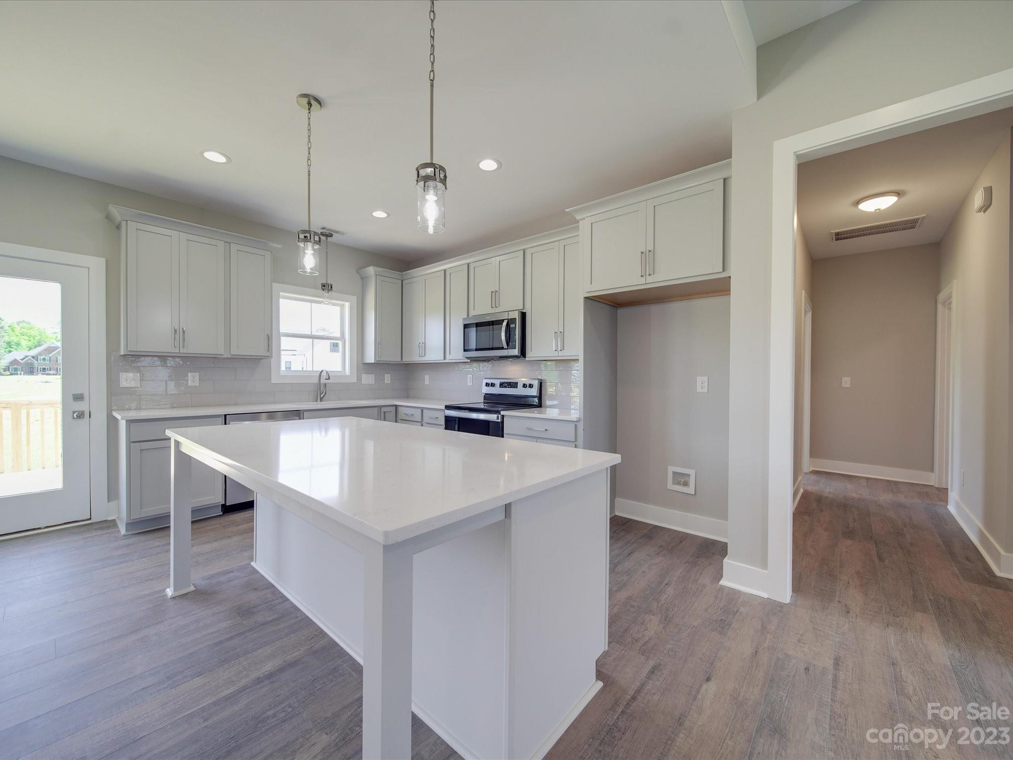 1321 Stack Road Monroe, NC 28112 - Photo 4 of 33 a kitchen with stainless steel appliances granite countertop a sink a stove a refrigerator and island with wooden floor