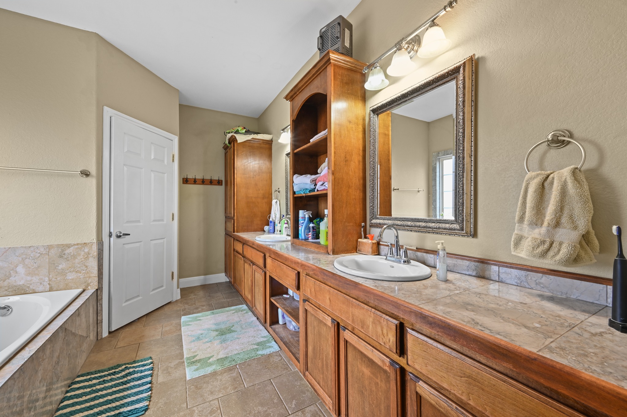 410 Simmons Family Farm Road Lockhart, TX 78644 - Photo 17 of 40 a bathroom with a granite countertop double vanity sink and a mirror