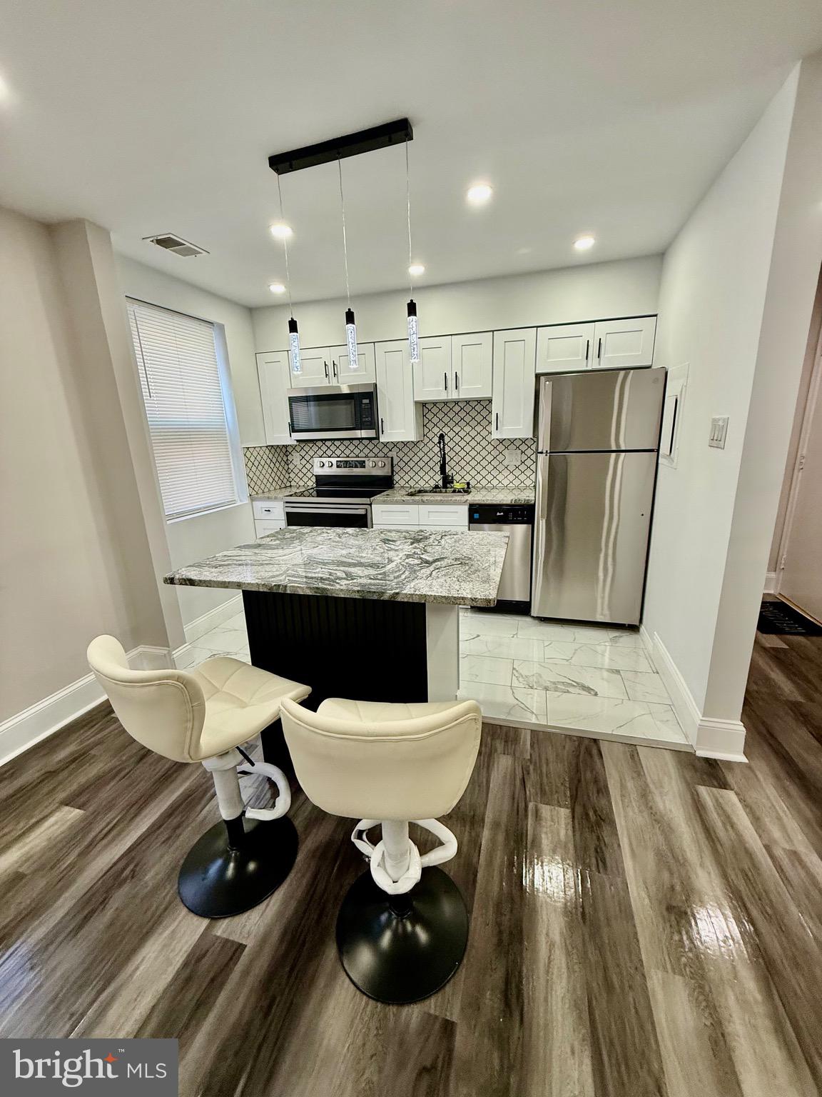 42 Conshohocken State Road, Unit 8A Bala Cynwyd, PA 19004 - Photo 1 of 15 a kitchen with stainless steel appliances a dining table chairs and a refrigerator