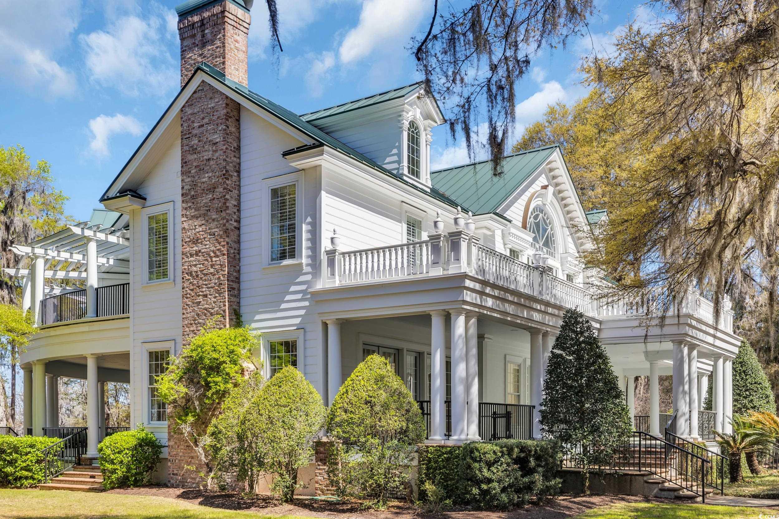 511 Rice Bluff Road Pawleys Island, SC 29585 - Photo 39 of 40 View of side of home featuring a balcony, metal roof, a chimney, and a pergola