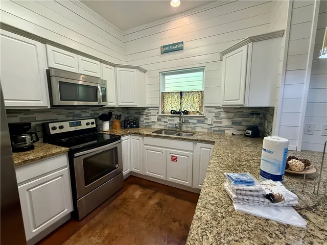 a kitchen with a stove a sink and a microwave