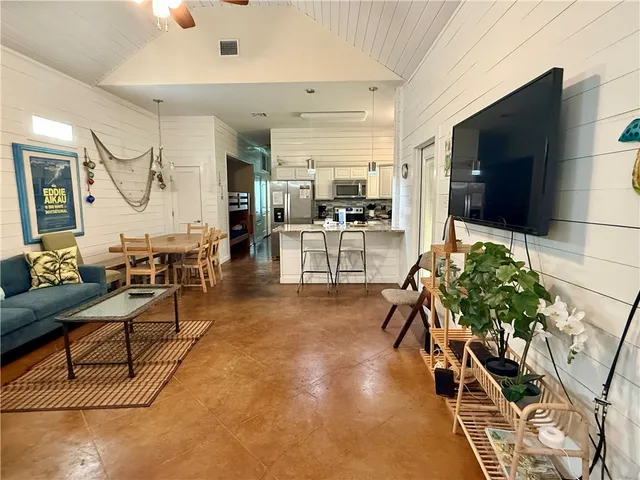a living room with patio furniture and a flat screen tv