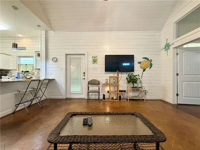 a room with table chairs and a flat screen tv