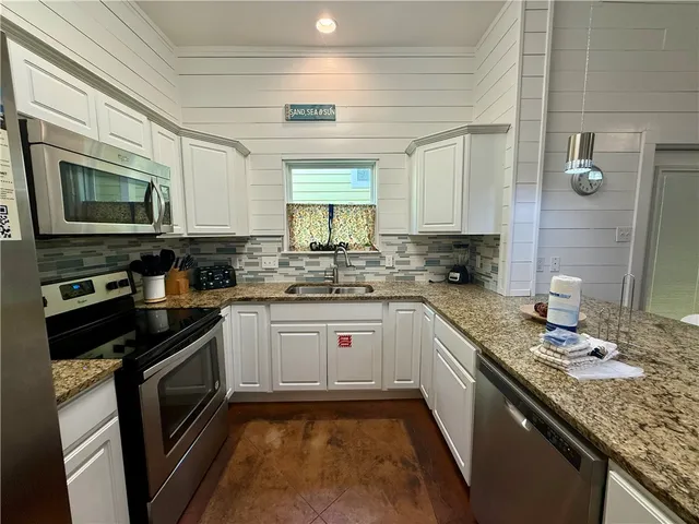 a kitchen with stainless steel appliances granite countertop a sink stove microwave and cabinets
