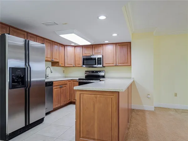 a kitchen with stainless steel appliances granite countertop a refrigerator a stove a sink and a microwave