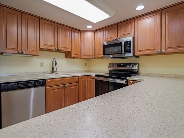 a kitchen with stainless steel appliances granite countertop a stove sink microwave and cabinets
