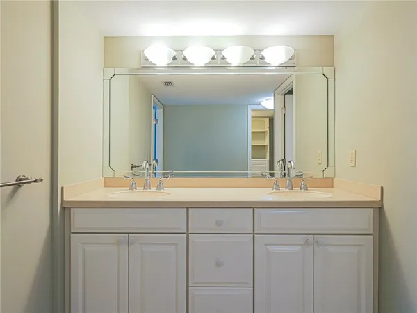 a bathroom with a double vanity sink and a mirror