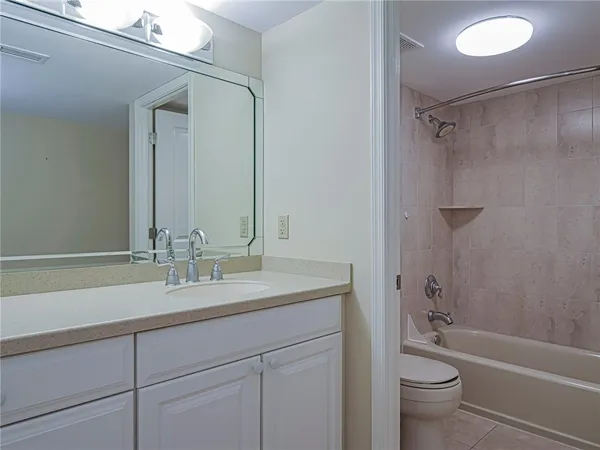 a bathroom with a granite countertop sink a toilet and shower
