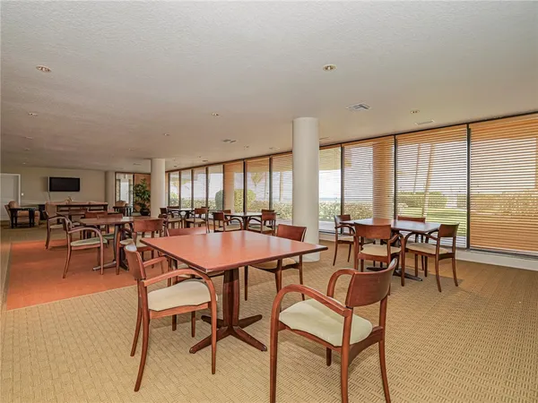 a dining hall with furniture a large window and a view of dining room
