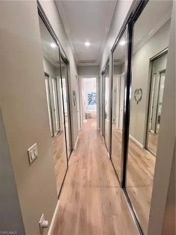a view of a hallway with wooden floor and staircase