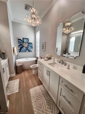 a spacious bathroom with a double vanity sink a mirror a bathtub and a window