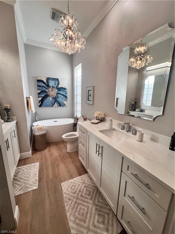 7651 Hernando Court Naples, FL 34114 - Photo 21 of 37 a spacious bathroom with a double vanity sink a mirror a bathtub and a window