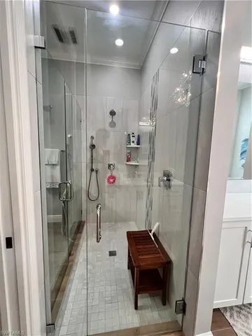a bathroom with a glass shower door and a sink