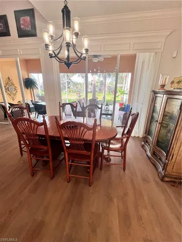 a view of a dining room with furniture wooden floor and chandelier