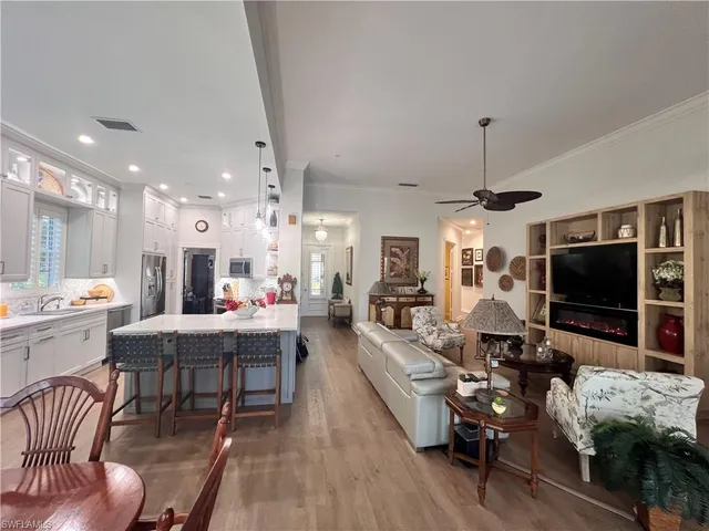 a living room with furniture a flat screen tv and kitchen view