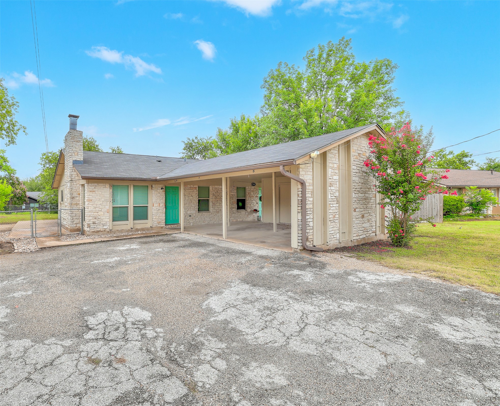 802 Ranch Road, Unit A Georgetown, TX 78628 - Photo 20 of 21 A charming stone-clad home features a covered carport and a vibrant front door.