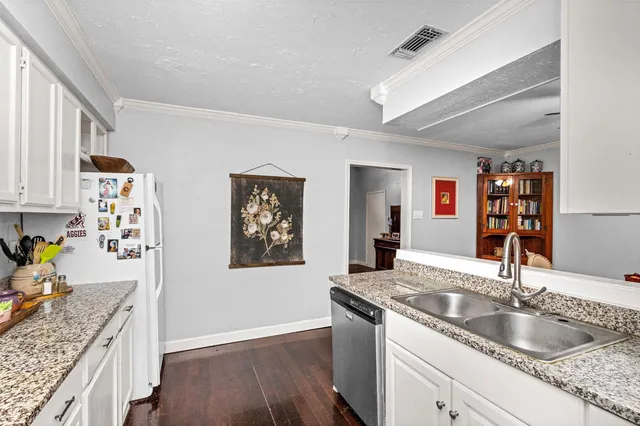 a kitchen with granite countertop a sink a stove and cabinets