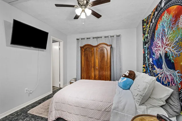 a bedroom with a bed and a flat screen tv